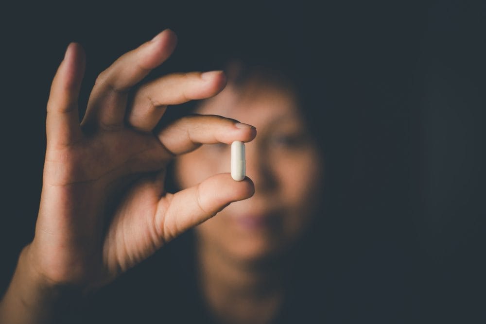 A woman about to take a pill that may be a placebo