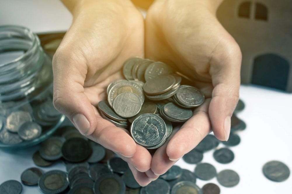 A pair of hands holding a lot of coins