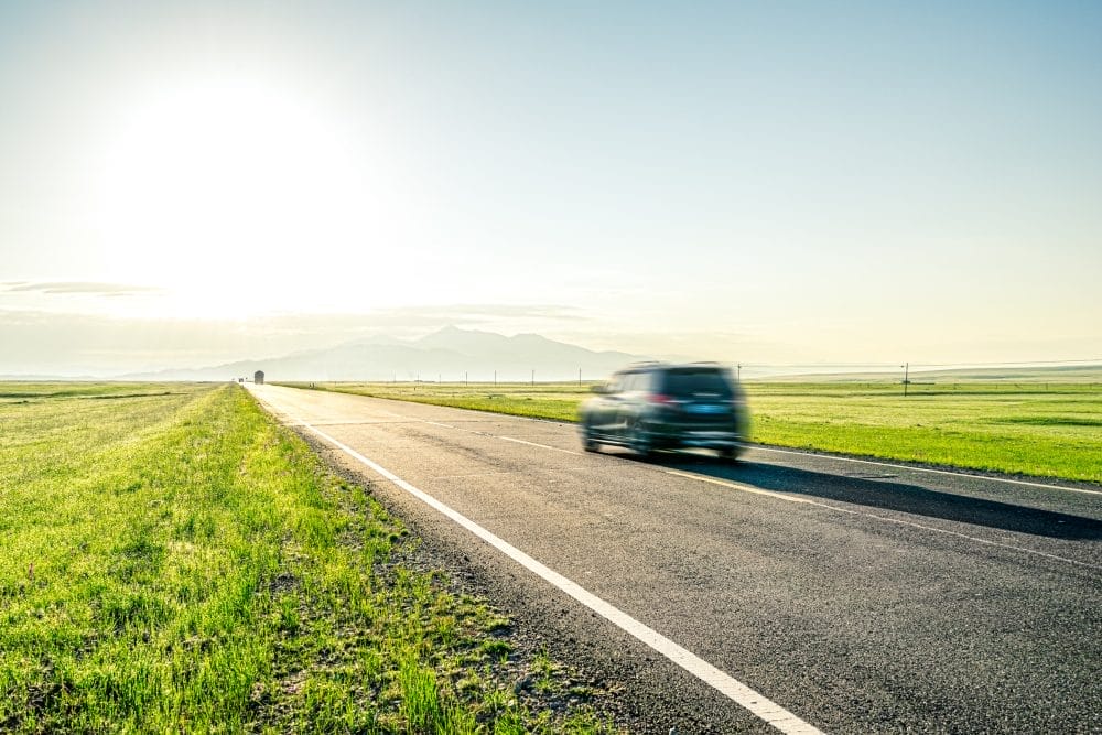 A car speeding down a highway in the southern part of the country