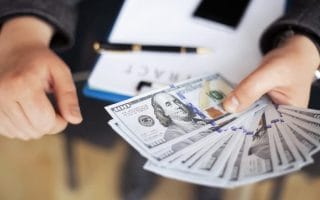 A man holding cash, building his wealth