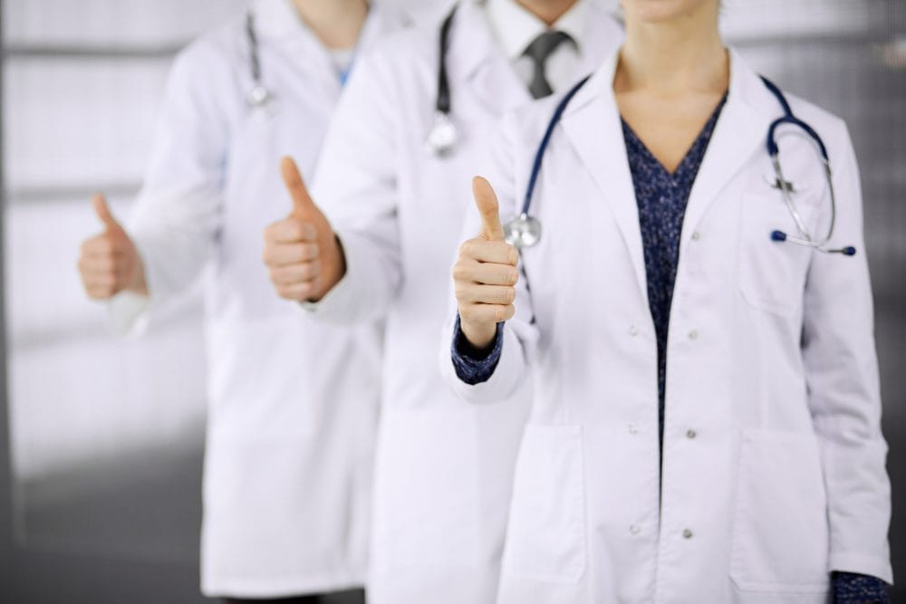 A group of doctors giving a thumbs up sign