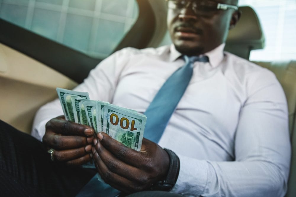 A rich person with his cash, showing a millionaire mindset