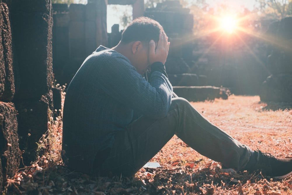 A man in a graveyard experiencing grief