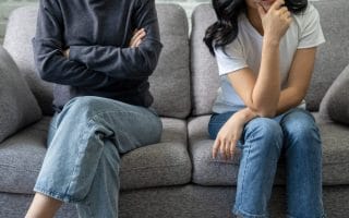 Two siblings sitting apart because they resent each other