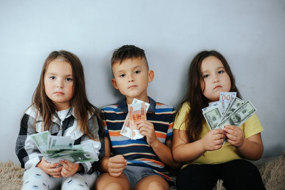 Three young children who learned financial mindset habits from their parents