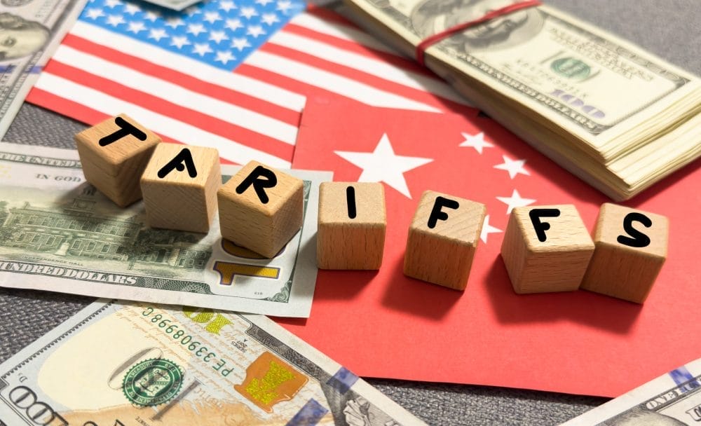 Americn and Chinese flags, with the word tariffs writen on top in blocks
