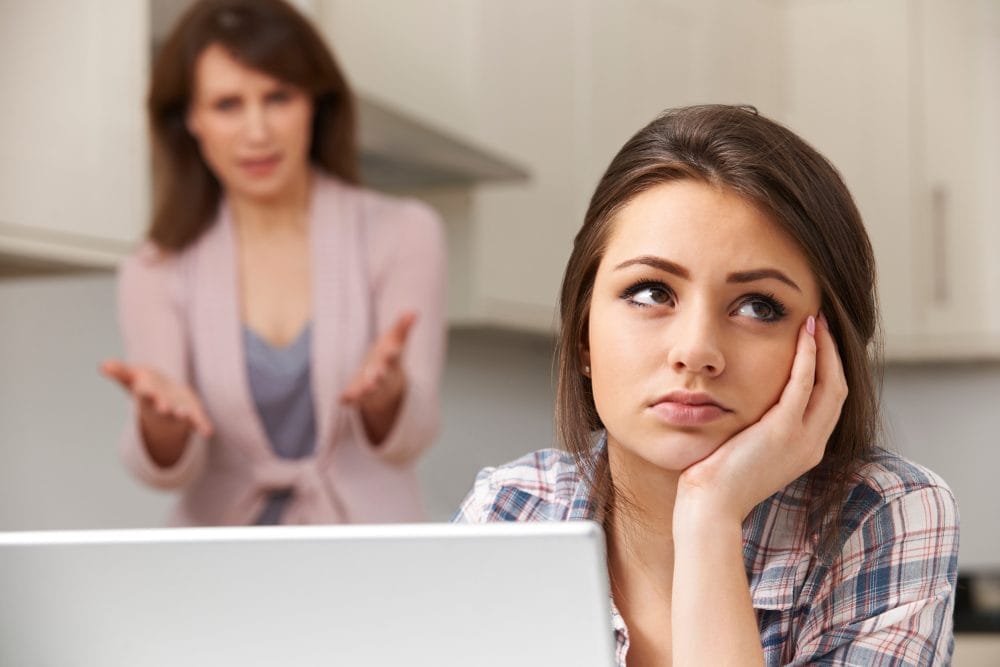 A young woman uncomfortable with how her parents are treating her