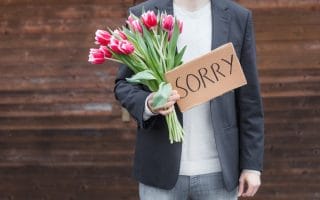 A man with flowers offering one of the apologies that do more harm than good