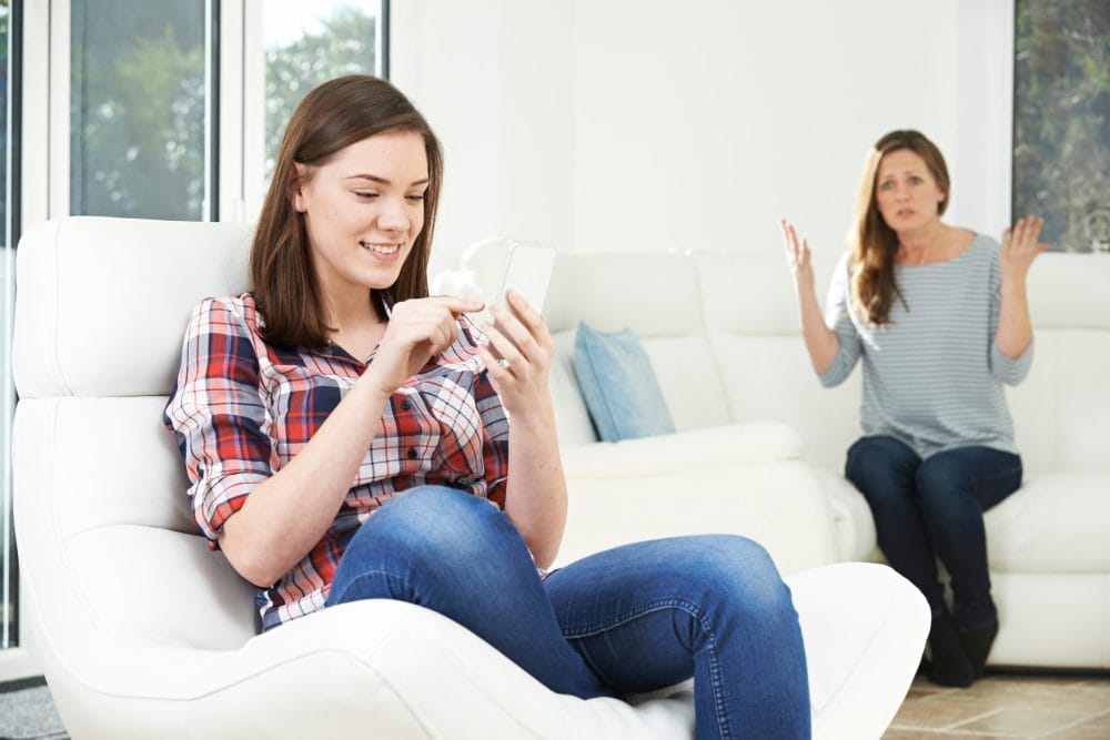 A woman nagging her adult children, including her daughter who ignores her