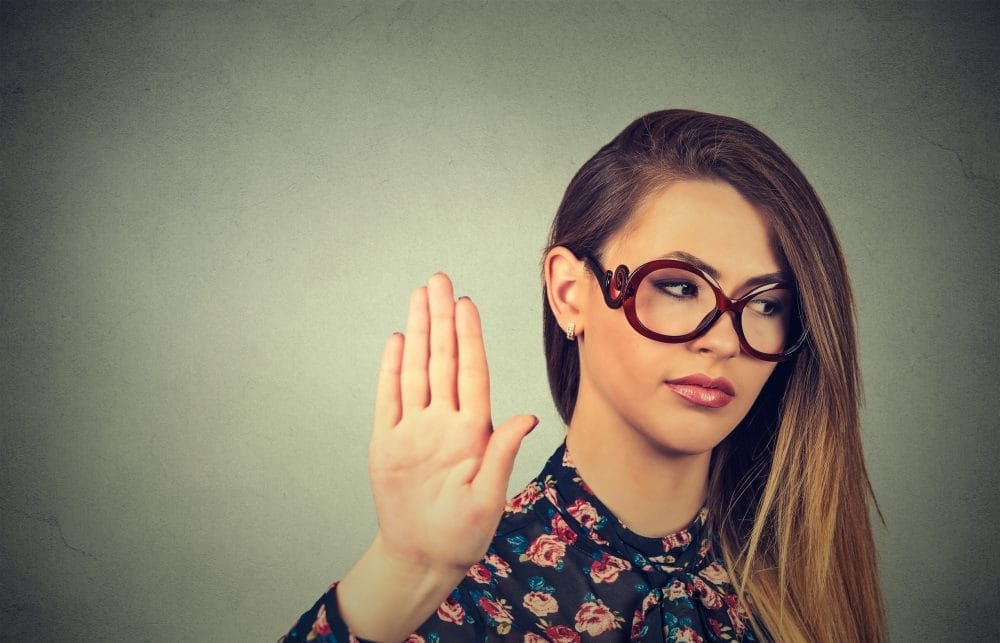 A woman in glasses hearing compliments that are actually deeply insulting