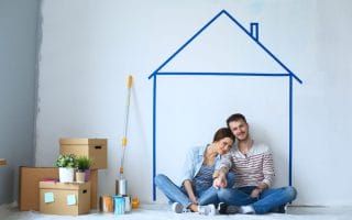 A married couple, painting and relaxing inside their new housing space
