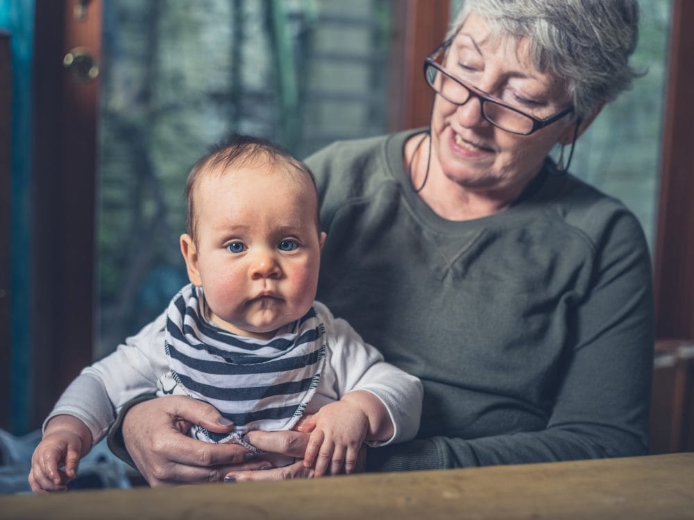 A grandparent babysitting her grandchild