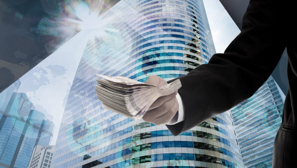 A man handing over a load of cashing, possibly because he was scamming others