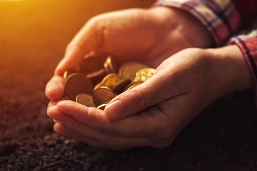 Someone with a handful of coins attempting to build financial freedom