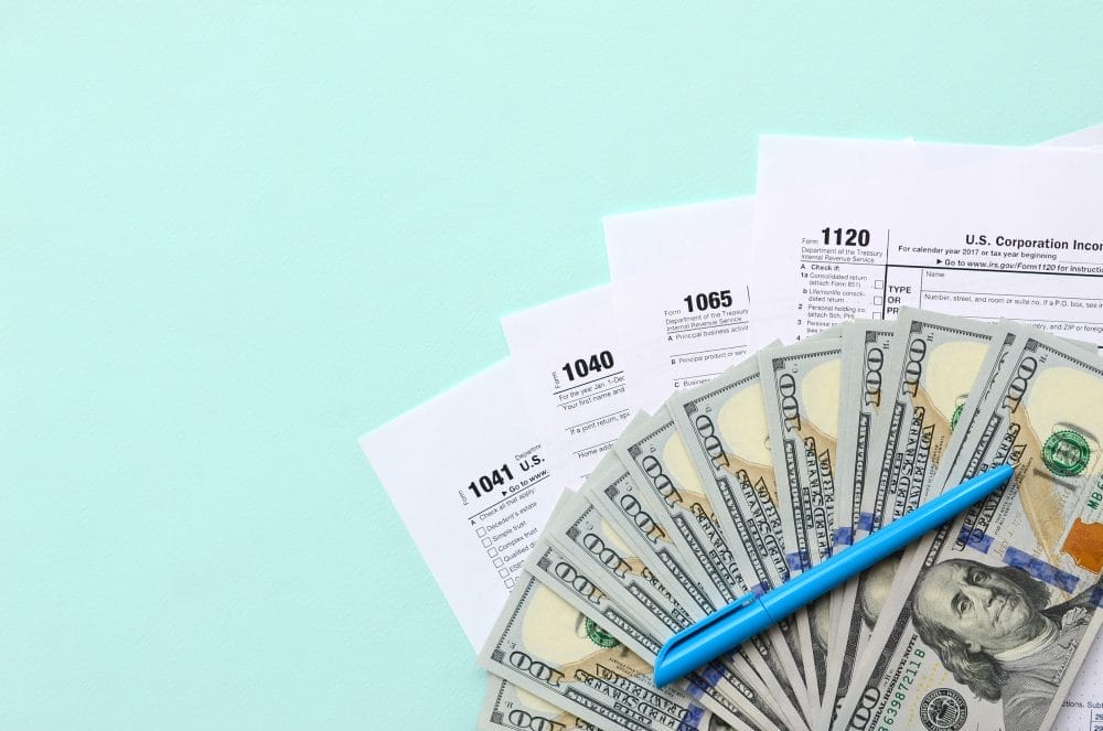 Someone filling out a load of tax forms