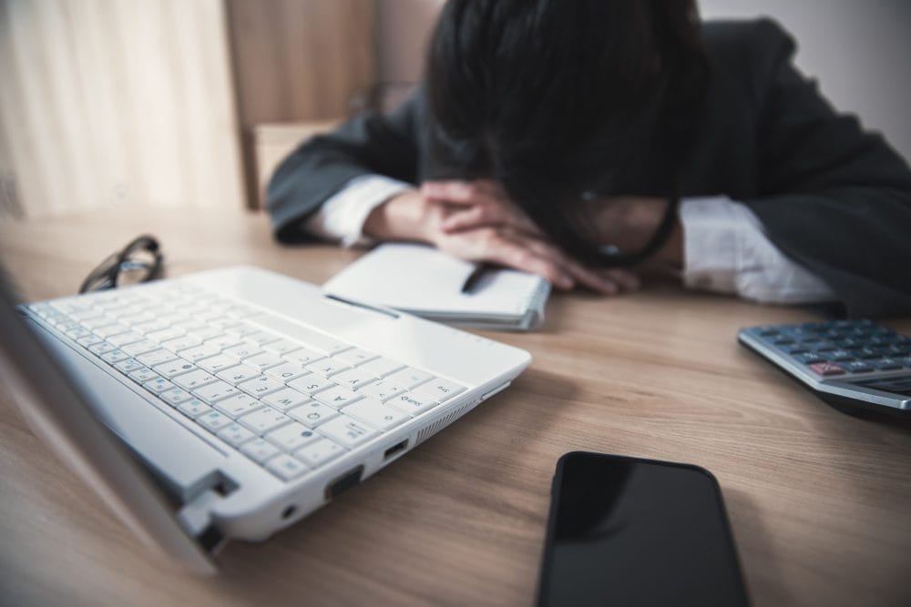 A fatigued person at their desk in a workplace