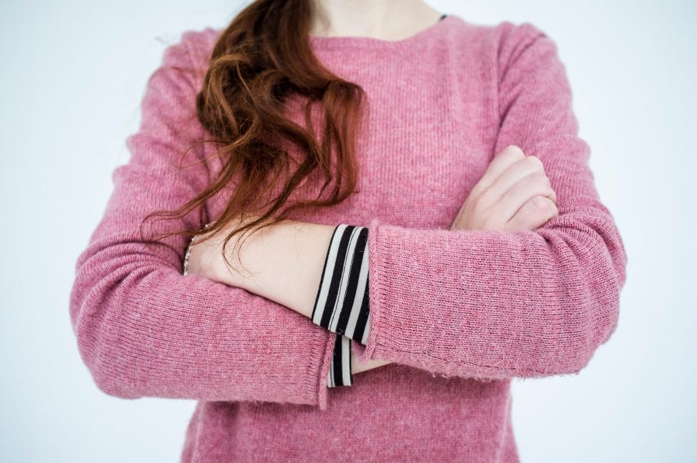 A woman crossing her arms, which is a stupid social cue